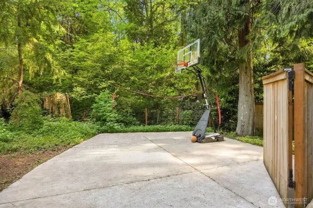 Newly relaid concrete pad—ideal for boat or RV parking, or as a spacious basketball area with netting to keep the ball in play. Features a wide, gated fence for easy access!