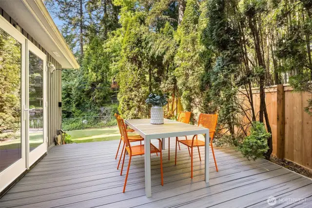 Installed in 2024, the weather-resistant Trex deck just off the kitchen provides a durable, low-maintenance space for alfresco dining and outdoor grilling—overlooking a flat turf play area designed for easy upkeep and everyday use.