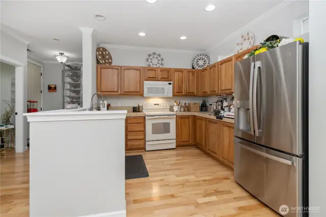 View of kitchen from laundry room. Half bath and entry way seen to the left.