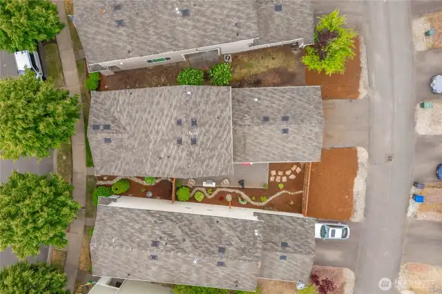 Arial view of home with full view of the roof and fenced yard.