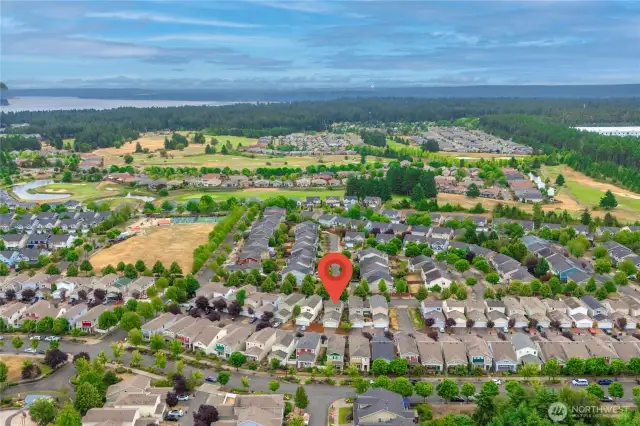 Arial view of the neighborhood. This home is under the flag. You are seeing the back of the home with garage access in the alley. On the left is Edgewater Park. Beyond is The Golf Club At Hawks Prairie.