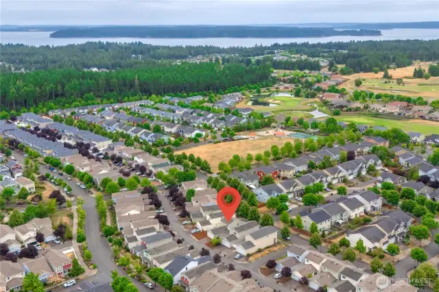 Arial view of the neighborhood. This home is marked by the flag with a side view of the garage with alley access. Grassy spot straight ahead is Edgewater Park, to the right is The Golf Club at Hawks Prairie.