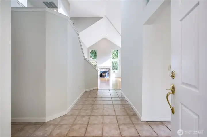 The front entrance opens to a dramatic entryway with vaulted ceilings, fresh interior paint, easy-to-clean tile floor, with just two steps in from the front door, and one step in from the attached garage.