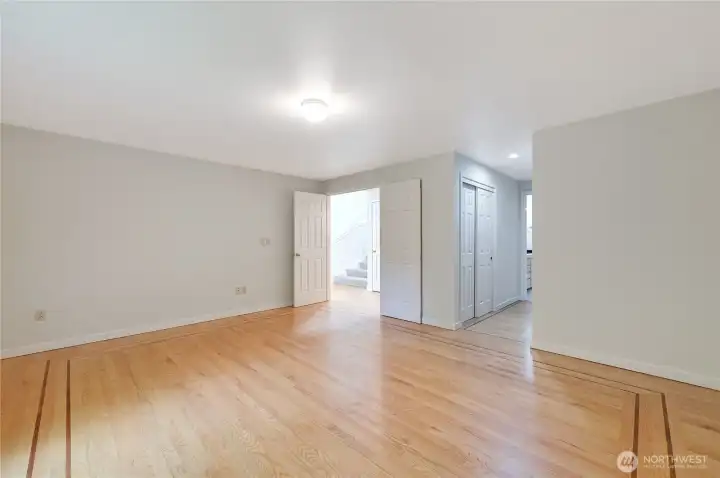 The primary, lower-level bedroom without the virtual staging. The door on the left leads to the main living space. down the hallway you'll find a walk-in closet, second closet, and full bathroom.