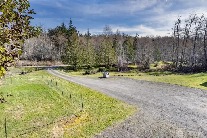 Sunny garden space on the left and well house on the right.