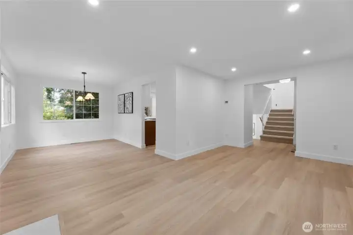 Living room wraps around to dining area with window overlooking backyard.