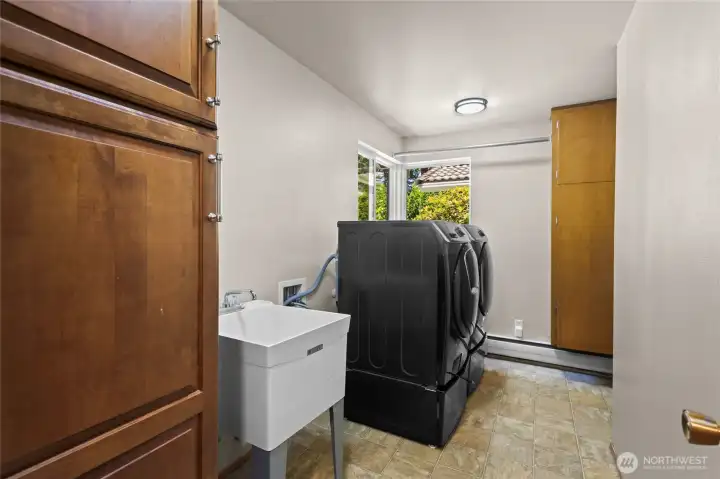 Large Utility Room with tons of storage and utility sink.Area hidden around the corner where you could stack Washer and dryer