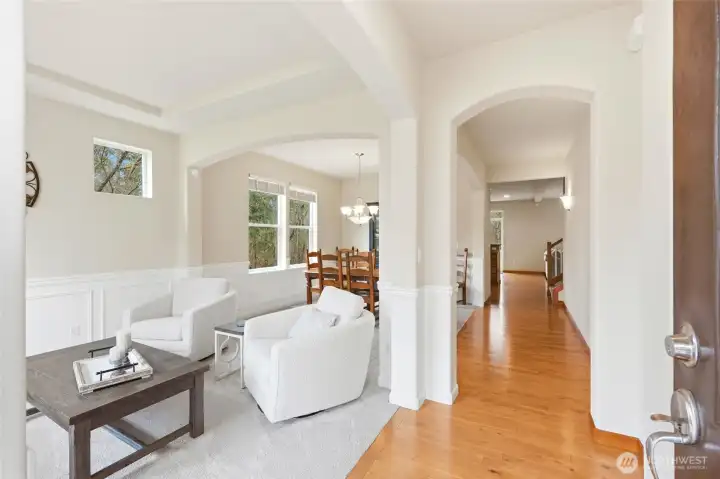Formal living and dining with wainscoting, arched entries, and hardwood floors Formal living and dining with wainscoting, arched entries, and hardwood floors