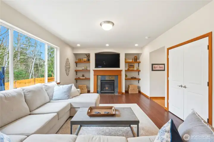 The kitchen opens to a large family room with a gas fireplace and picture windows framing the wooded backdrop. The kitchen opens to a large family room with a gas fireplace and picture windows framing the wooded backdrop.