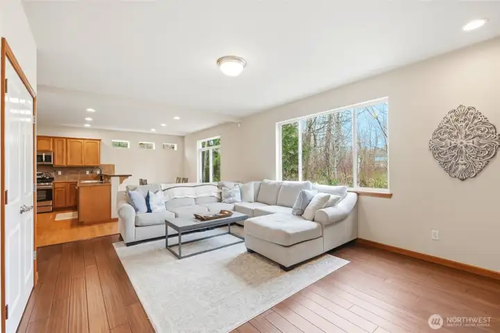 The kitchen opens to a large family room with a gas fireplace and picture windows framing the wooded backdrop. The kitchen opens to a large family room with a gas fireplace and picture windows framing the wooded backdrop.