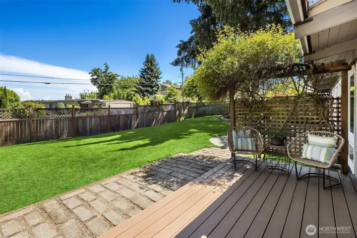 The expansive, fully fenced backyard offers rare flat lawn space in Enatai — ideal for summer gatherings, play, gardening, or simply relaxing beneath the mature trees and open sky.