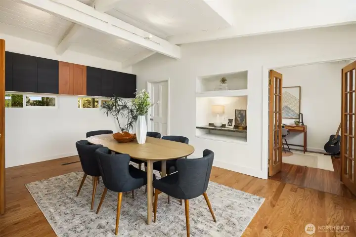 Vaulted ceilings and warm wood floors create an inviting dining space, while French doors and adjacent flex spaces allow the room to easily adapt for entertaining, work-from-home needs, or everyday gathering.