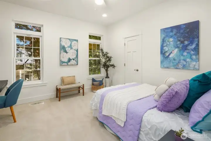 Generously sized upper-level bedroom with tall windows, built-in desk space, and a bright, airy layout designed to flex easily for work, study, or guests.