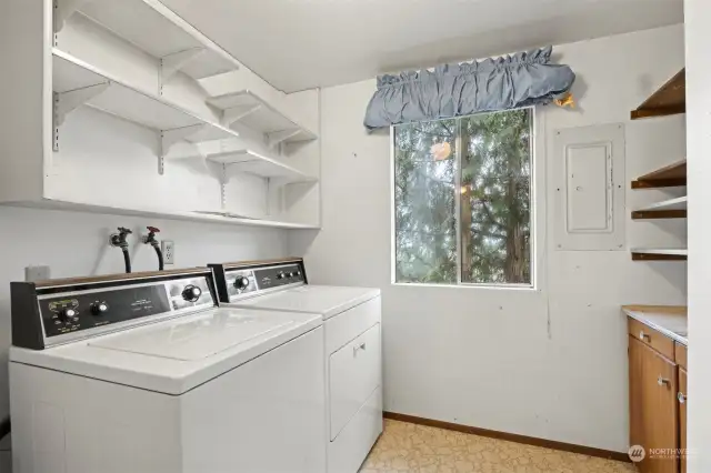 The laundry room is spacious and has an abundance of storage.