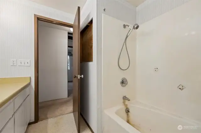 Looking toward the hall from the full bathroom, with the laundry room beyond.