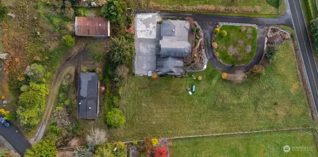 Looking down on the home (black comp roof) and the out building (metal room).