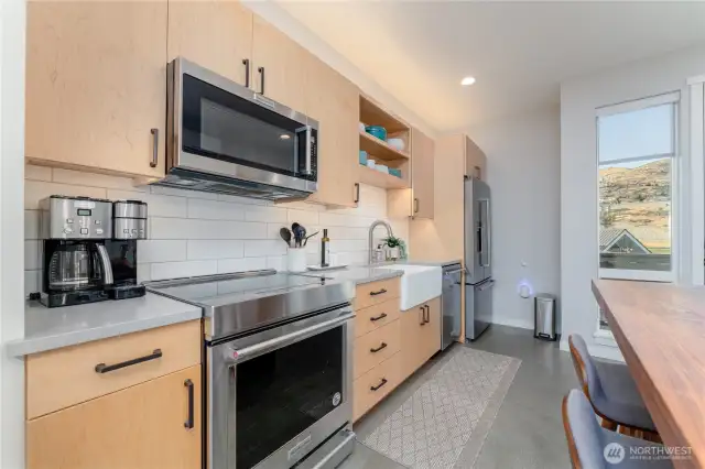 view 3 of kitchen w/ custom dining room table and high end appliances.