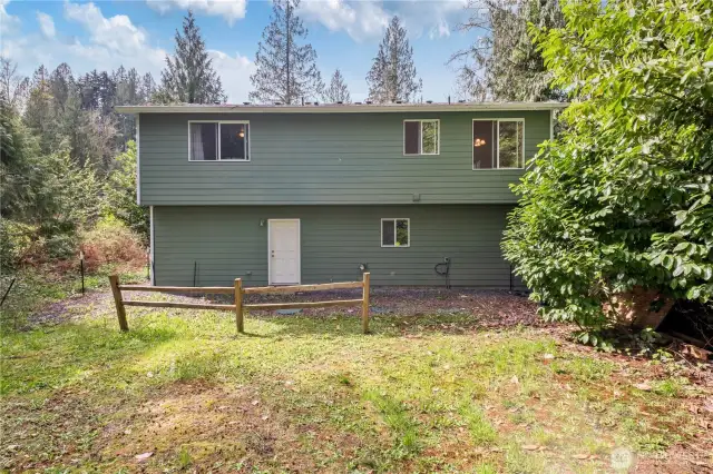 The house-flipper, in me, would add a slider off of the kitchen and build a deck with stairs down to the yard. I'd do the same with the lower window off of the laundry room, but with French doors.