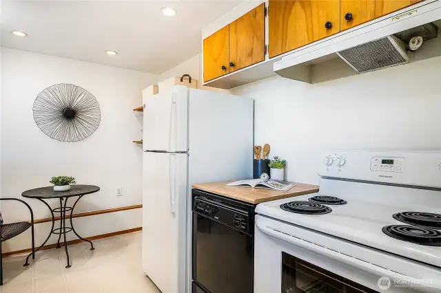 Pantry shelving tucked next to fridge and enough room for a small table