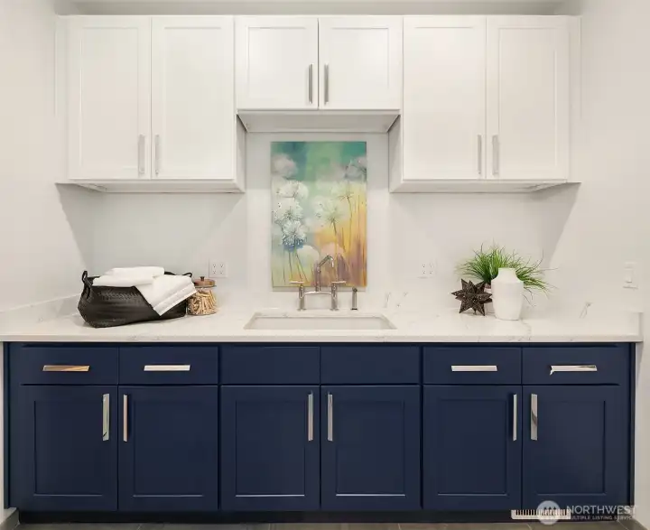 Laundry room features quartz countertops, tons of storage and and extra deep wash sink.