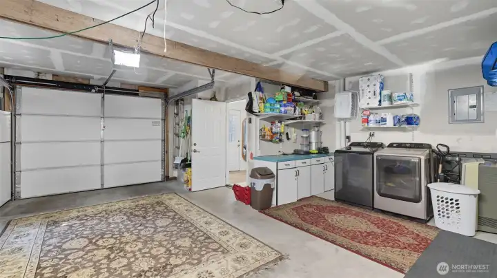Spacious garage with convenient laundry area and extra storage.