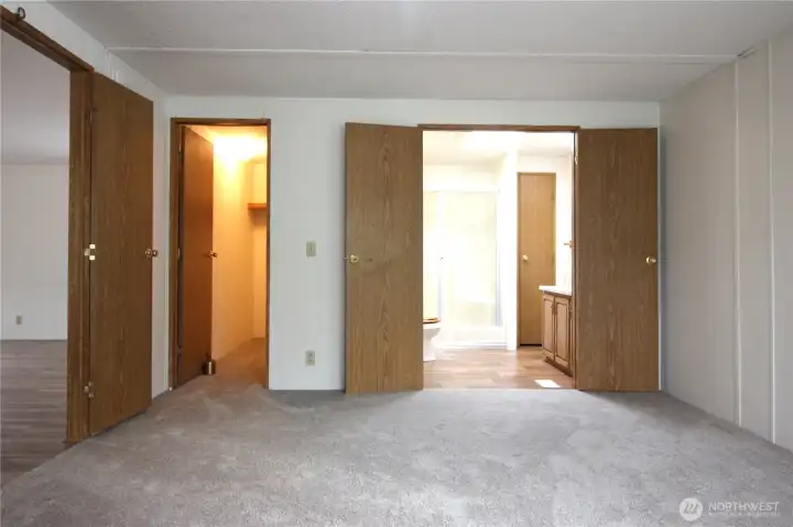 Primary suite with double doors leading into the room and double doors leading into the bathroom. Walk in closet.