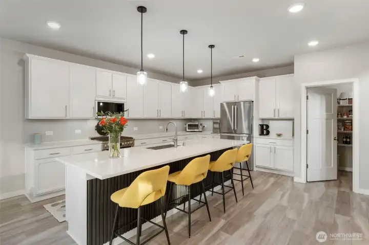 Timelessly beautiful white kitchen with quartz counters and Stainless Steel appliances. Gas range.