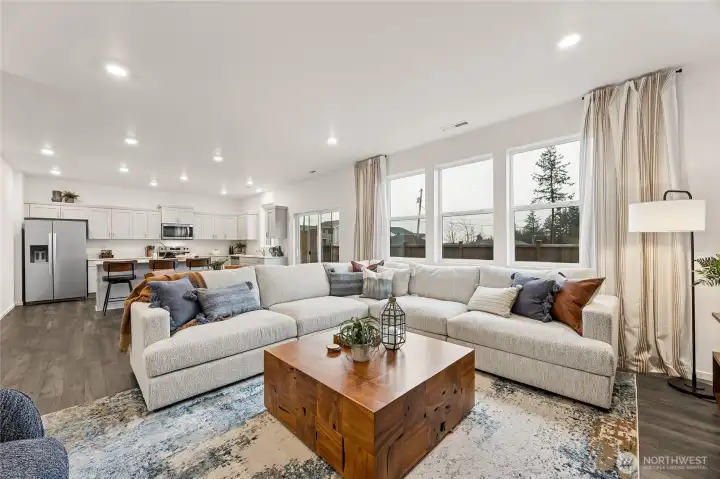 Very open living to kitchen with large windows for natural light. Actual home is under construction and colors, materials, and finishes may vary. See site agent for details.