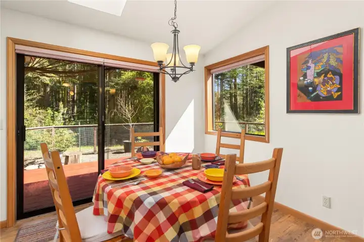 Dining room with a laminate floor and sliding glass door leading to one back deck and a fenced area for your furry friends.