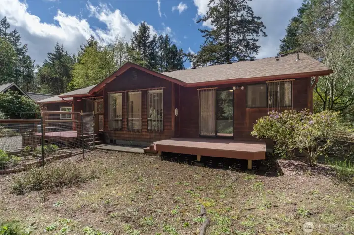 Back yard showing two decks- one by the dining room and another by the primary bedroom.