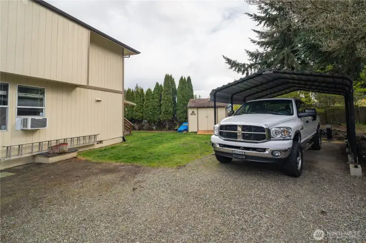 Side yard with lots of additional parking with one covered area for truck