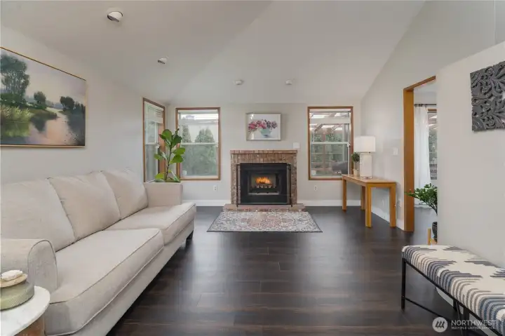 Vaulted Living room with wood burning fireplace and upgrade rich laminated floors