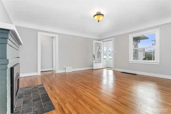 Living room features gas fireplace and refinished wood floors