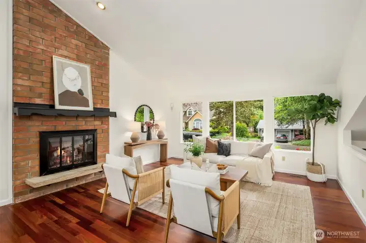 Bright and spacious living room enhanced by vaulted ceilings, oversized windows, and an inviting, comfortable ambiance.