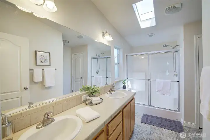 Primary bathroom with double sink vanity and walk-in shower.