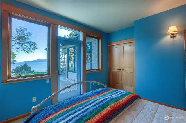 Main floor guest bedroom with door outside and water views.