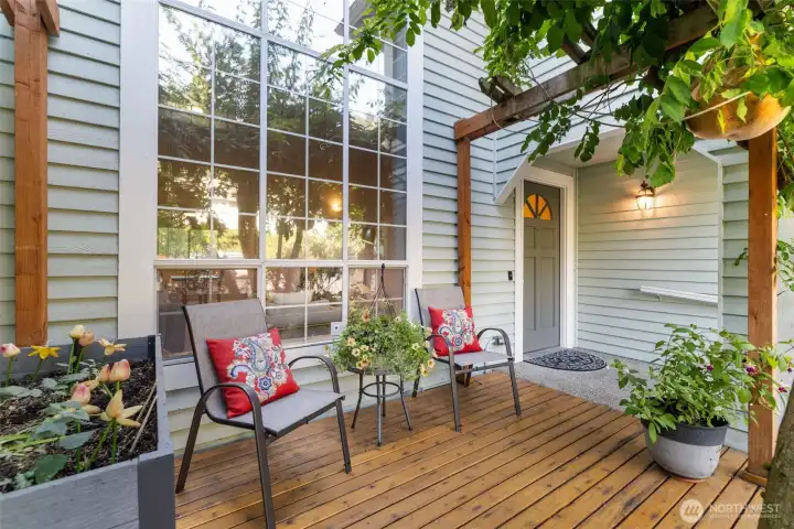 Front deck sitting area and covered entry with garden space.
