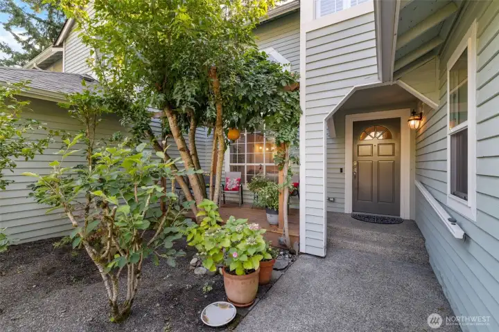 Front deck sitting area and covered entry with garden space.