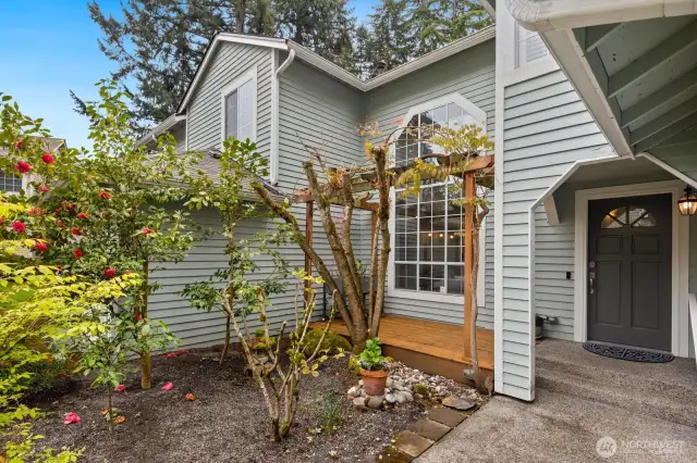 Front deck sitting area and covered entry with garden space.