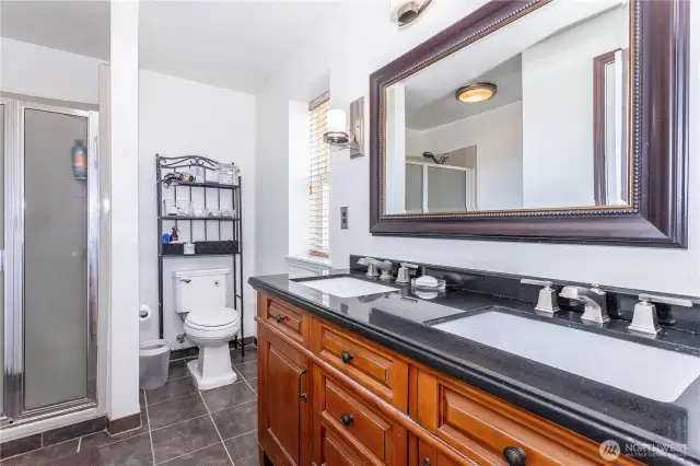 Primary bathroom has 3/4 size shower (only) with 2 sinks. Updated with brushed nickel faucets and quartz countertops. Closet is to the left and IS surprisingly small for a primary bedroom.