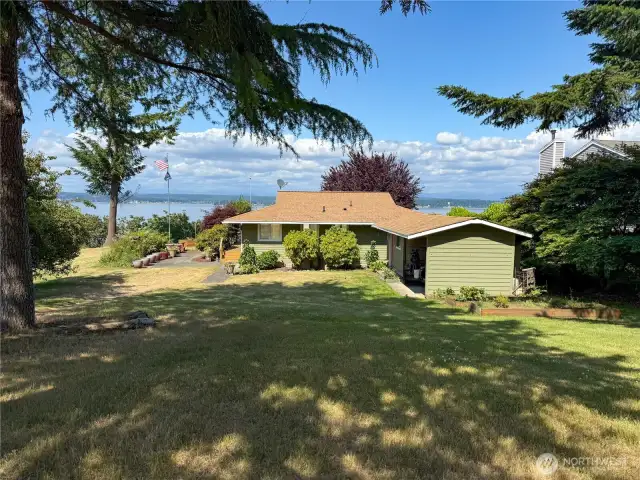 Fruit trees and gardens on this sunny bluff side bungalow.  Tide rights to beach below.