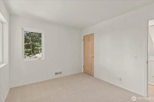 Two large windows in the bedroom overlook the yard, framing peaceful mountain views and filling the space with natural light.