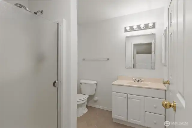 The lower level includes a storage area with built-in shelving—ideal for a wine room or extra storage—offering organized space to keep essentials neatly tucked away.