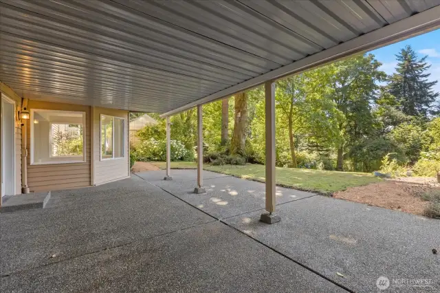 The covered patio offers year-round weather protection, creating a comfortable outdoor space for relaxing or entertaining while providing convenient entry to the lower leve