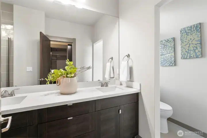 Primary bath has dual sinks and sleek cabinets and countertops Primary bath has dual sinks and sleek cabinets and countertops