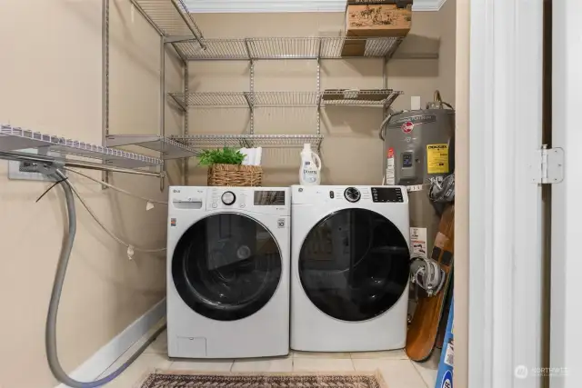 Laundry room with newer water heater.