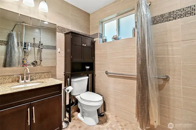 En suite bath with ADA accessible shower.