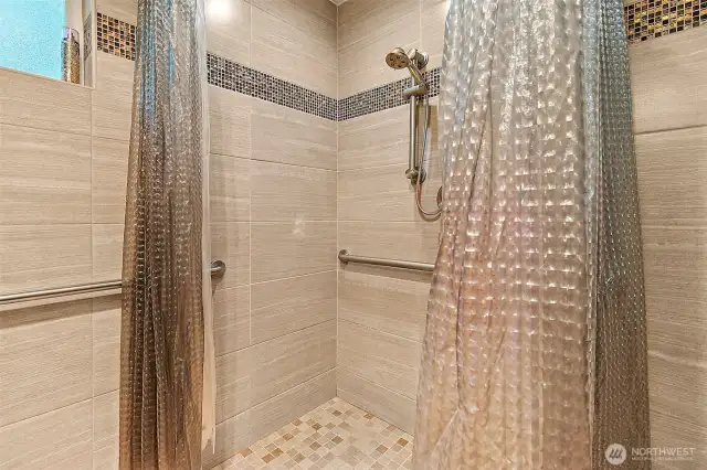 Floor-to-ceiling tile throughout the primary en suite.
