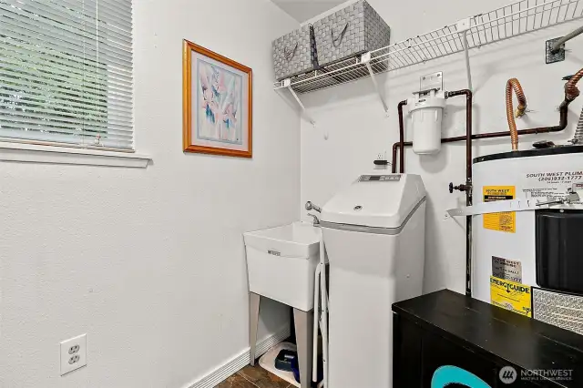 Laundry/Utility room with water softener system and utility sink.