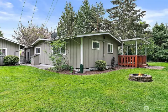 Mature landscaping surrounds the home with various flowering shrubs and bushes.